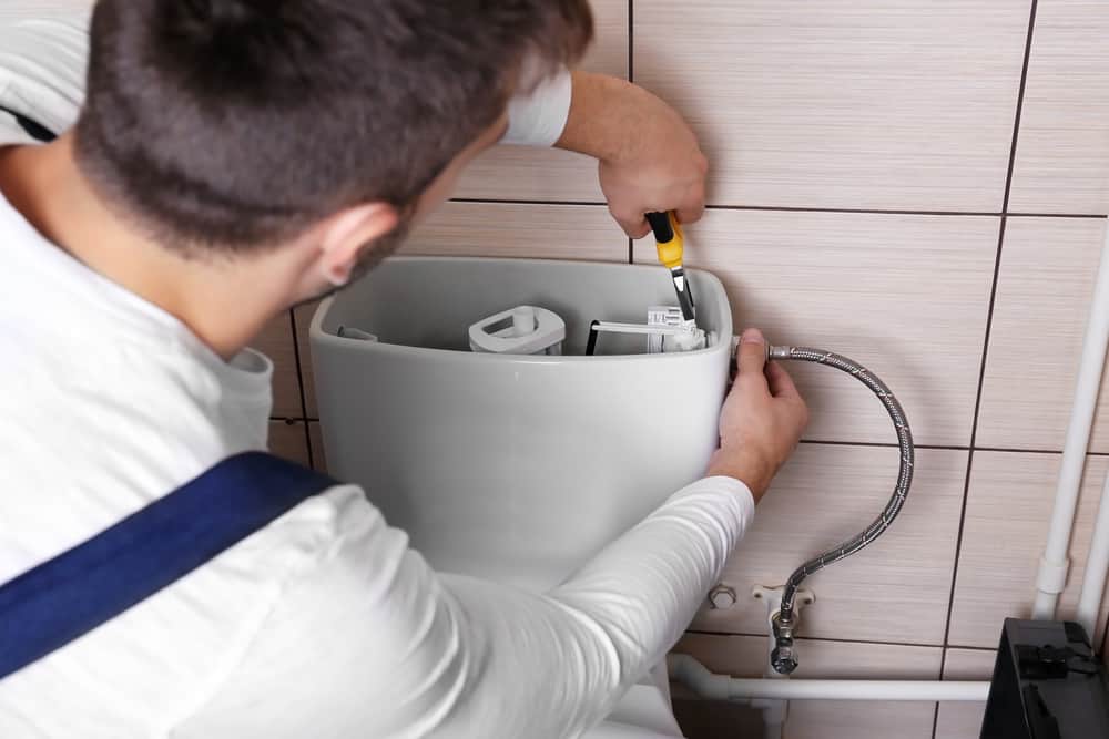 Plumber Fixing Clogged Toilet Drain