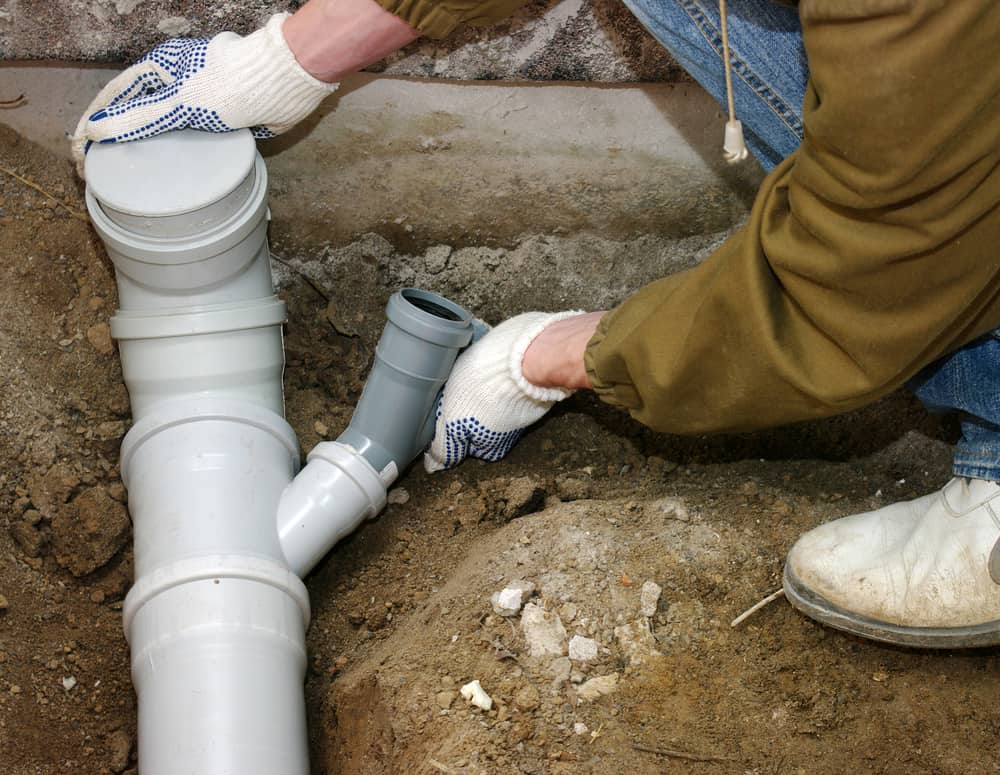 Plumber Fixing Sewer Drain
