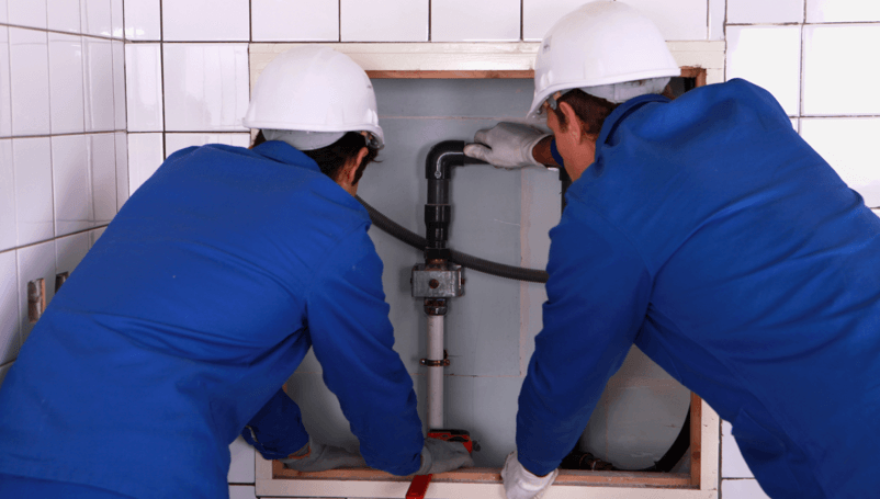 Two Plumbers fixing pipes